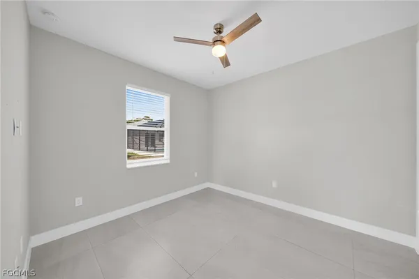 an empty room with a window and a fan