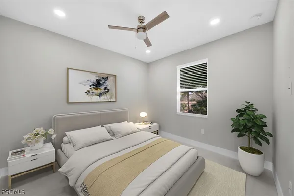 a bedroom with a large bed and a potted plant