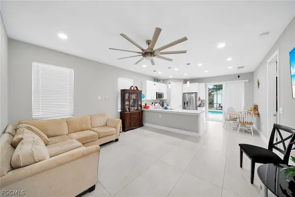 a living room with furniture and a view of kitchen
