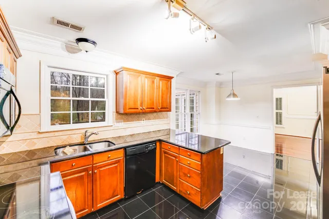 a kitchen with stainless steel appliances granite countertop a sink and a granite counter tops with a large window