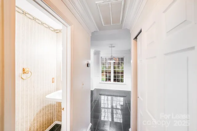 a view of a hallway with wooden floor and a window