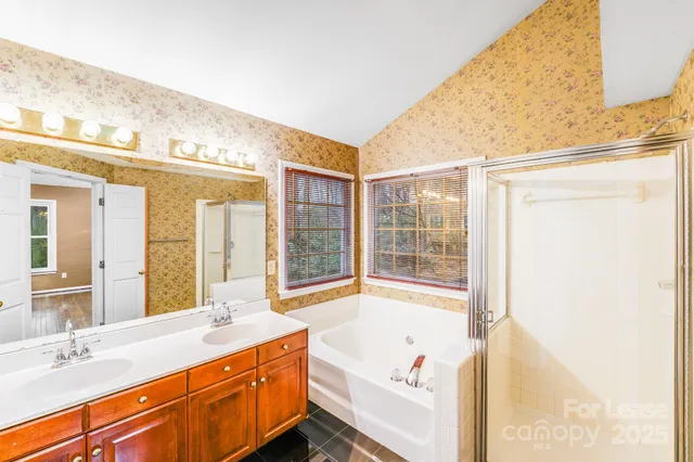 a bathroom with a tub sink and mirror