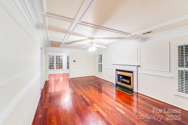 a view of empty room with wooden floor