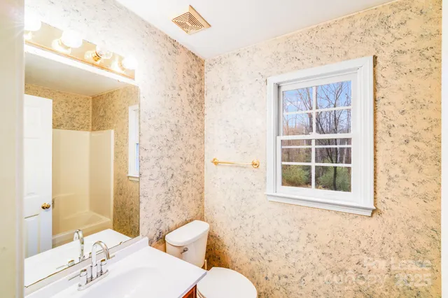 a bathroom with a sink mirror and a toilet