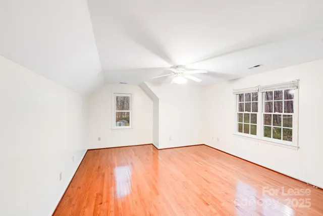 an empty room with a window and wooden floor