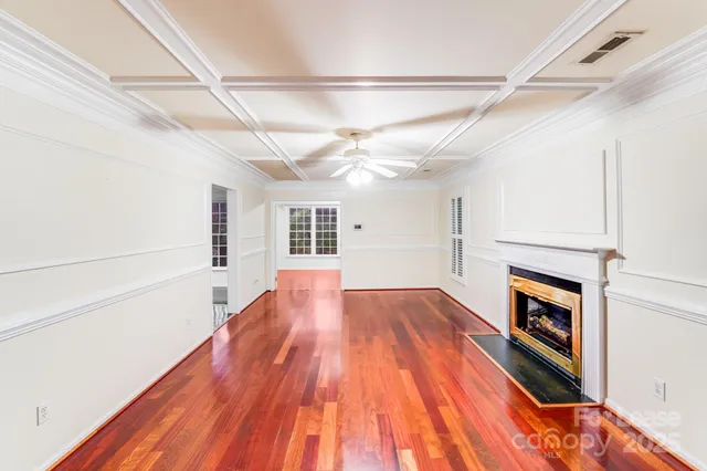 a view of empty room with wooden floor and fireplace
