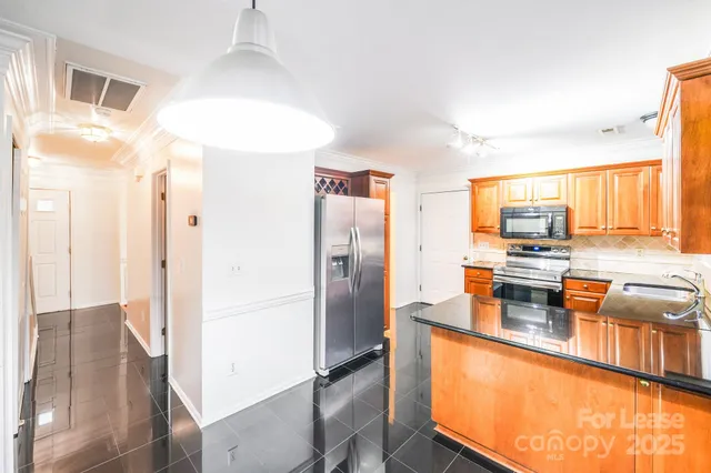 a kitchen with stainless steel appliances granite countertop a refrigerator and a stove