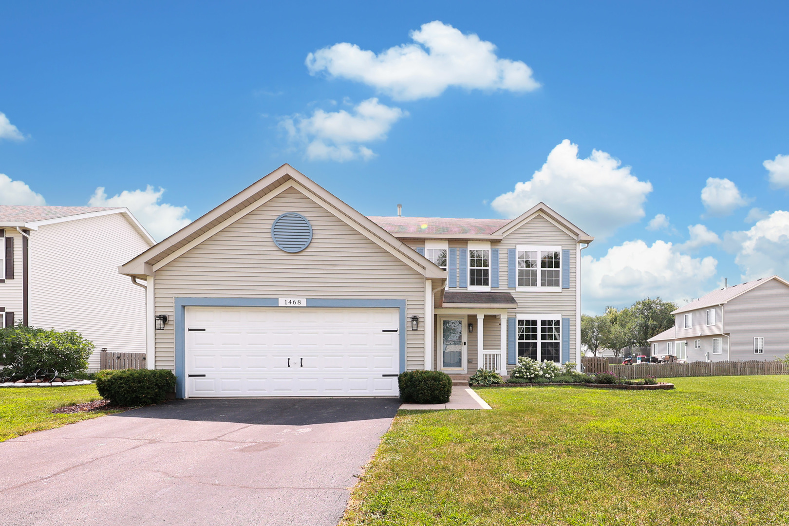 a front view of a house with yard and green space
