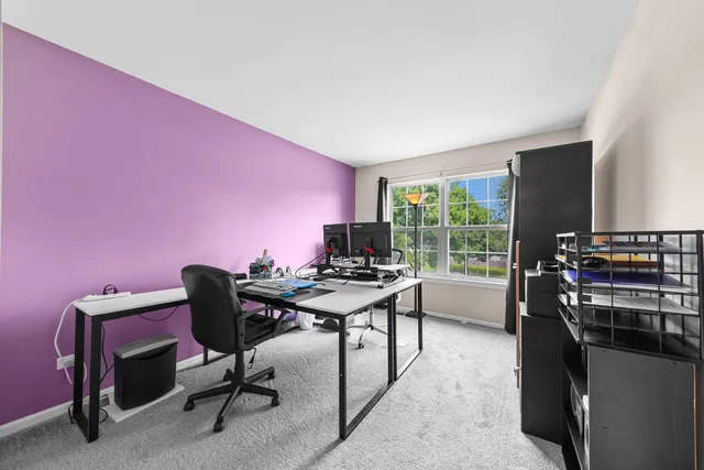 a view of a workspace with furniture and a window