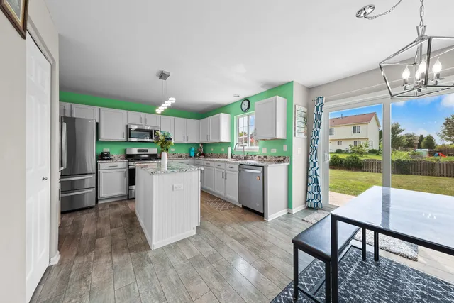 a kitchen with a table chairs refrigerator and cabinets