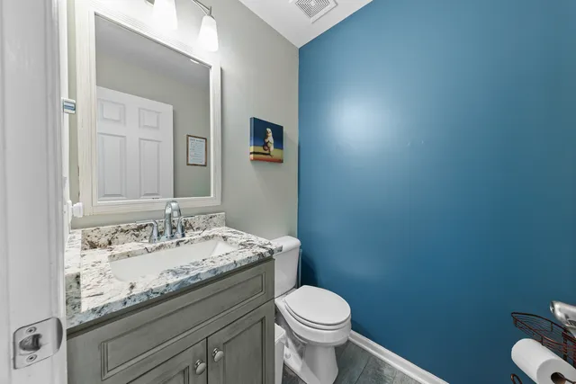 a bathroom with a granite countertop sink a toilet and mirror