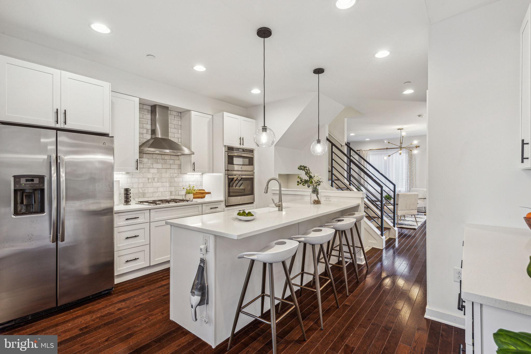 159 East Allen Street, Unit 2 Philadelphia, PA 19125 - Photo 7 of 35 a kitchen with kitchen island a wooden floor and white appliances