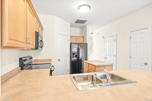 a kitchen with a refrigerator sink and cabinets
