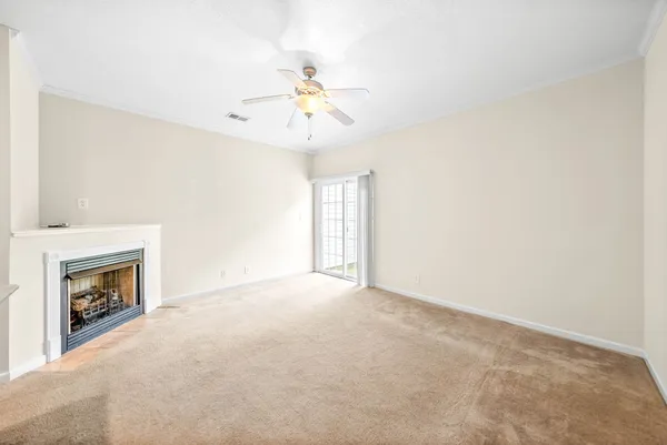 an empty room with windows and fireplace