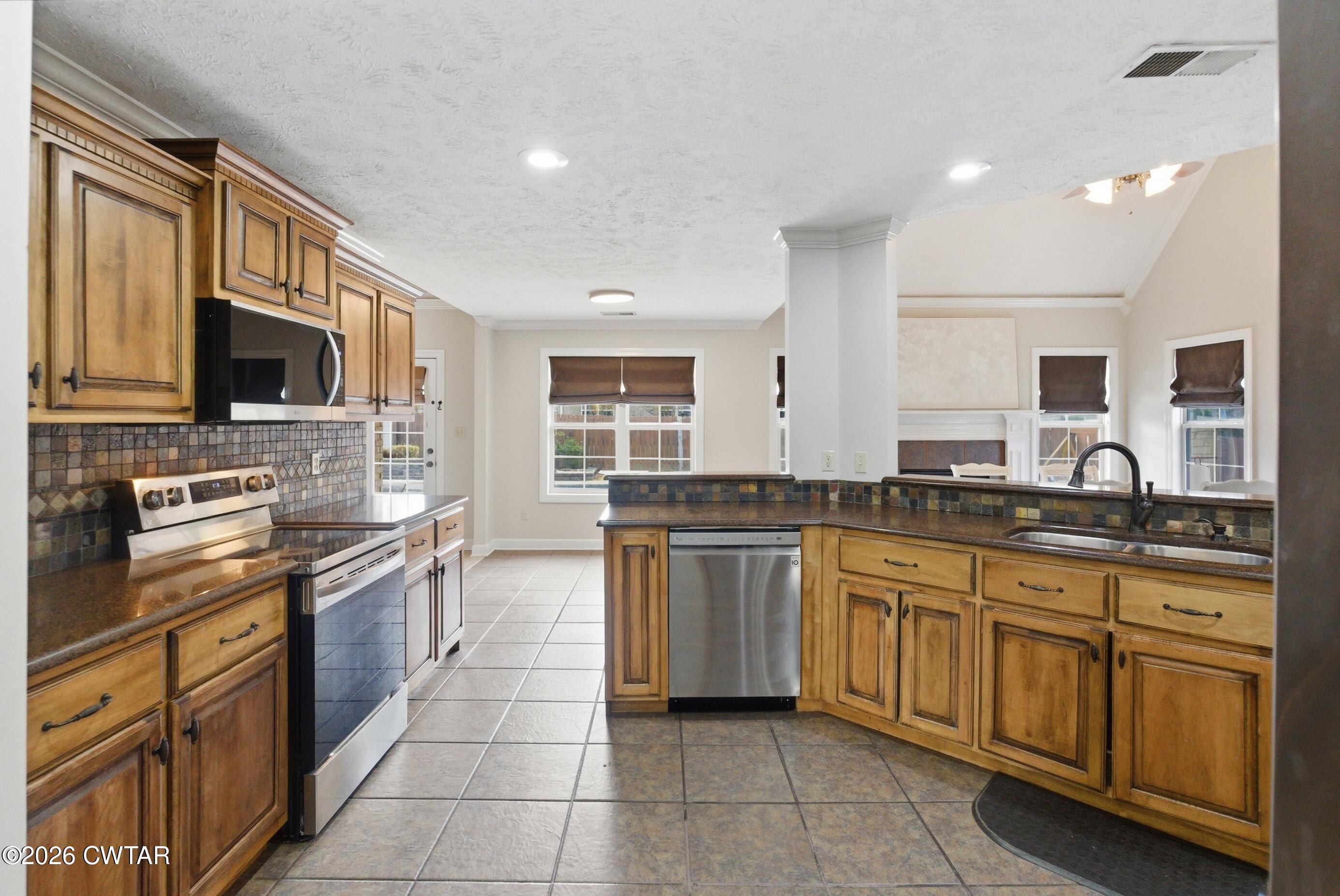 325 Harvest Ridge Lane Medina, TN 38355 - Photo 4 of 43 a kitchen with stainless steel appliances granite countertop a stove top oven a sink dishwasher a dining table and chairs
