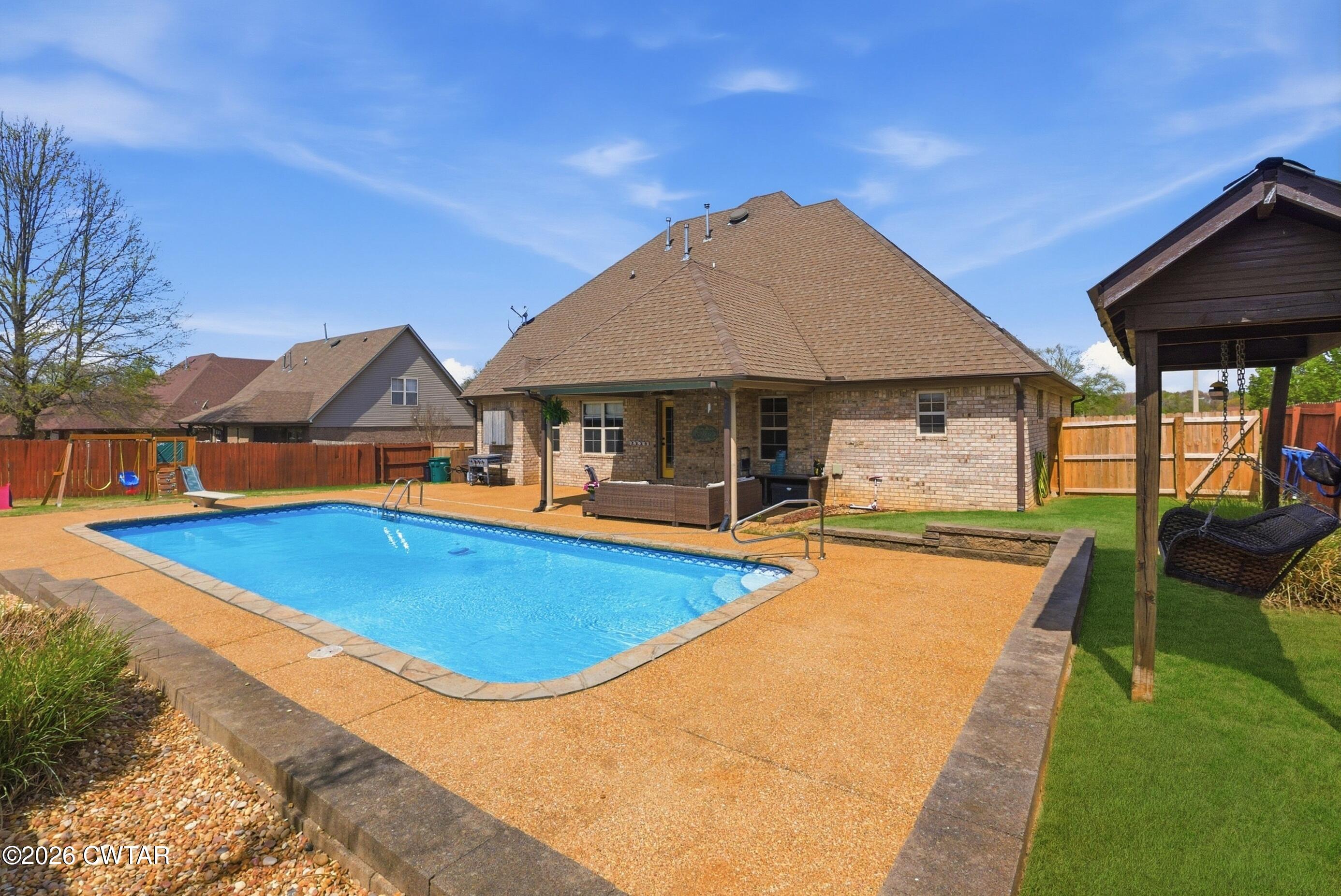325 Harvest Ridge Lane Medina, TN 38355 - Photo 42 of 43 a view of swimming pool with lawn chairs under an umbrella