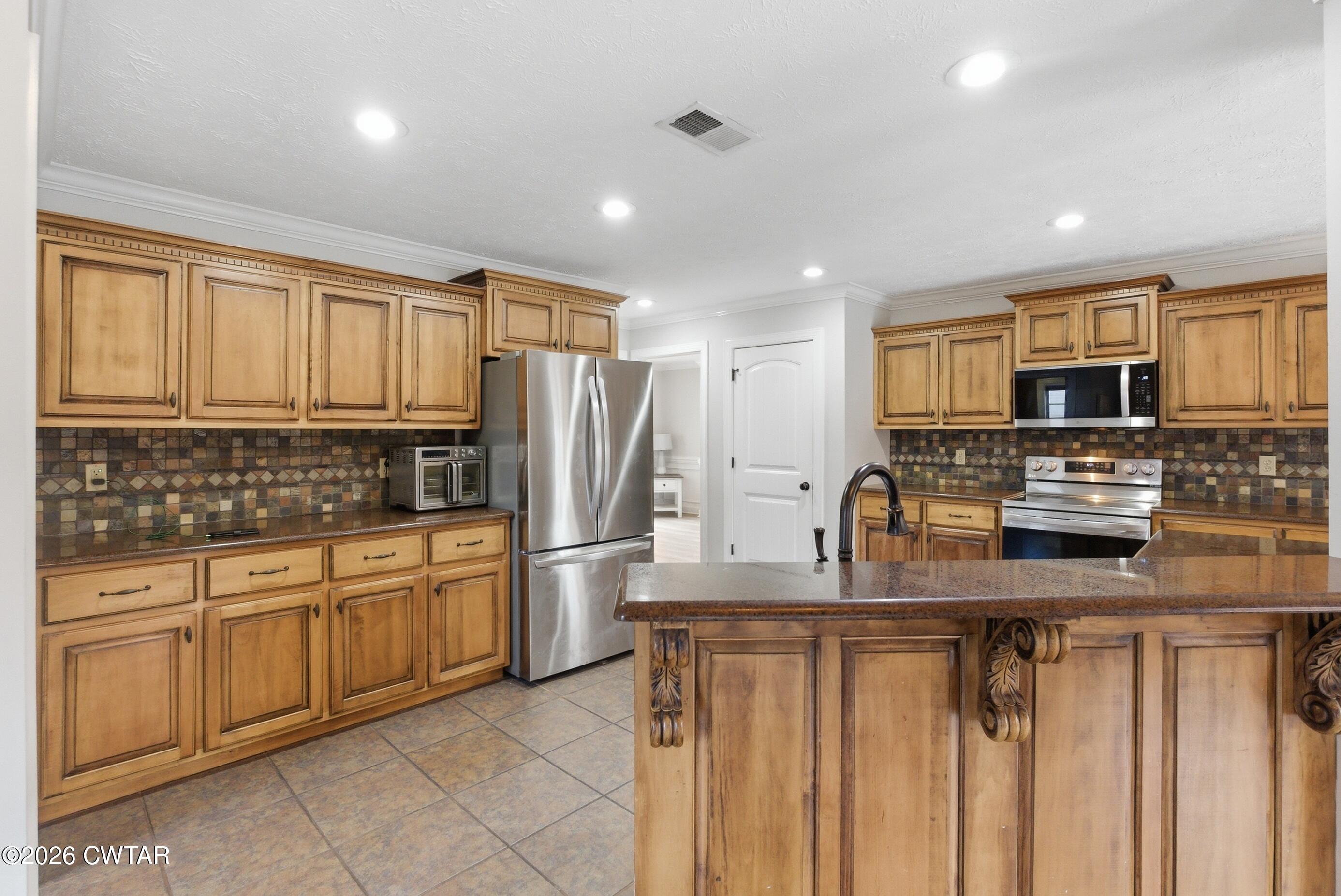 325 Harvest Ridge Lane Medina, TN 38355 - Photo 5 of 43 a kitchen with stainless steel appliances granite countertop a refrigerator sink and cabinets