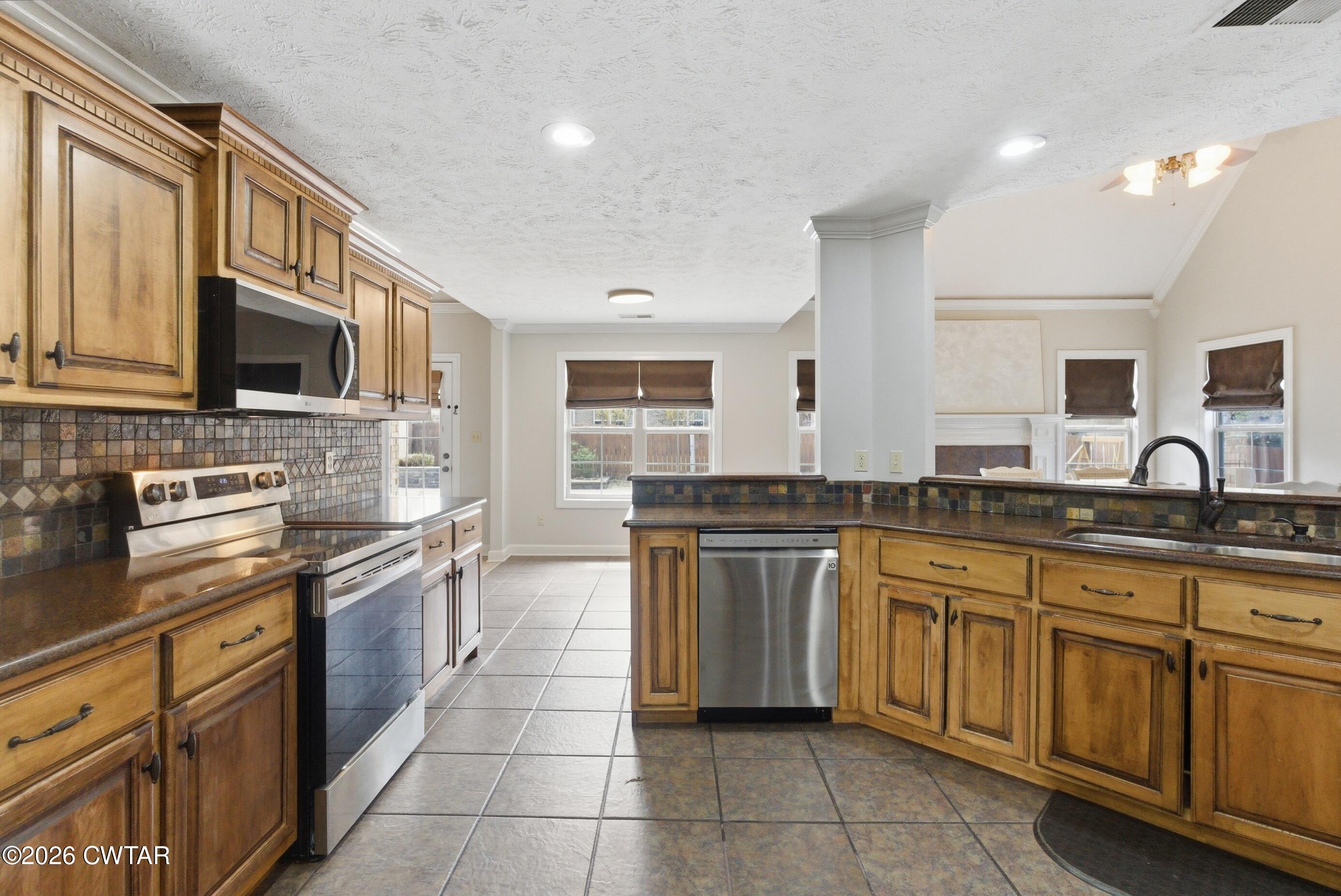 325 Harvest Ridge Lane Medina, TN 38355 - Photo 8 of 43 a kitchen with stainless steel appliances granite countertop a stove top oven a sink dishwasher a dining table and chairs