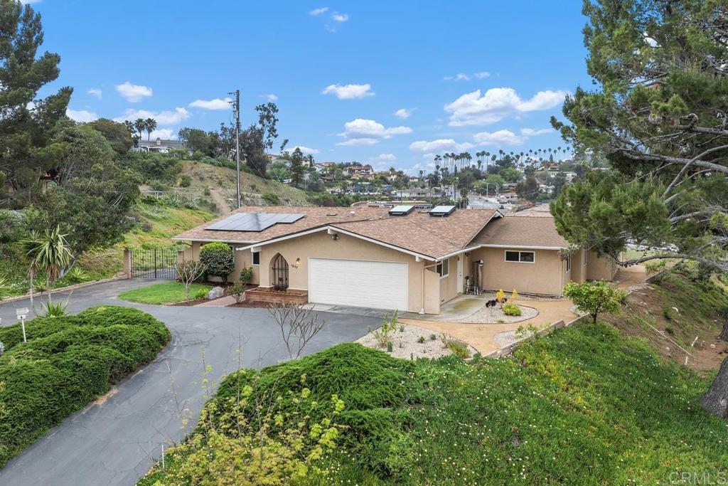 a view of a house with a yard and table and chairs under an umbrella