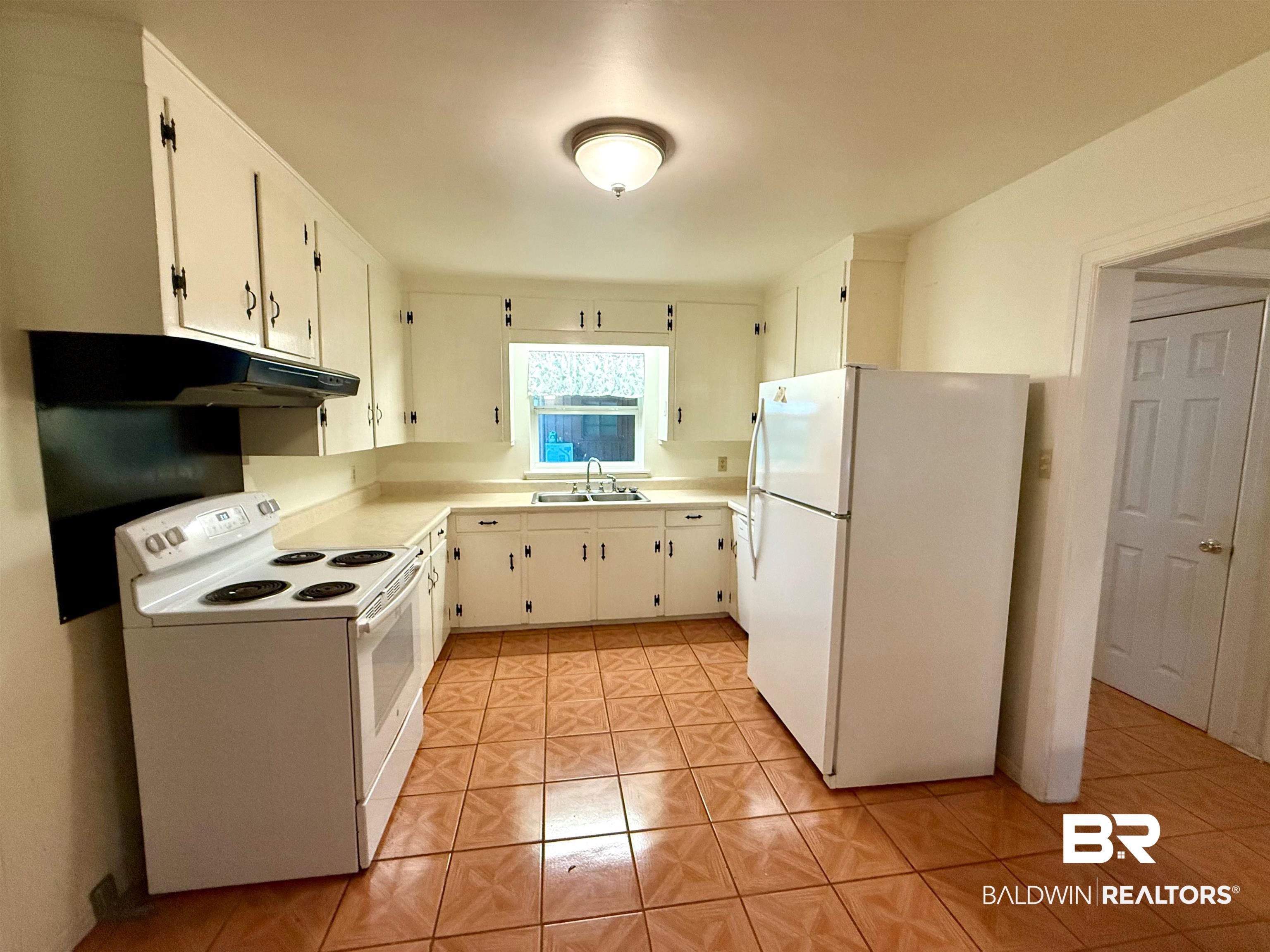 403 Sutherland Drive Mobile, AL 36611 - Photo 4 of 8 Kitchen with white appliances, a sink, light tile patterned flooring, and light countertops
