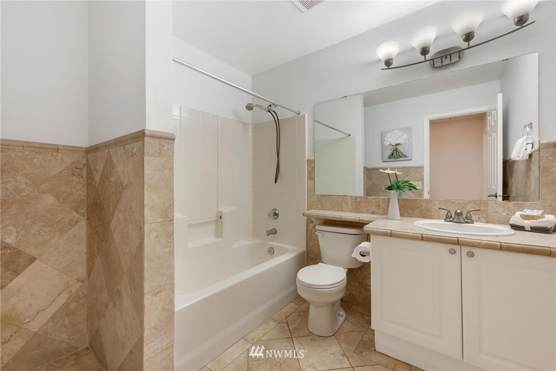 18505 Southeast Newport Way, Unit E320 Issaquah, WA 98027 - Photo 12 of 18 a bathroom with a sink a toilet and shower