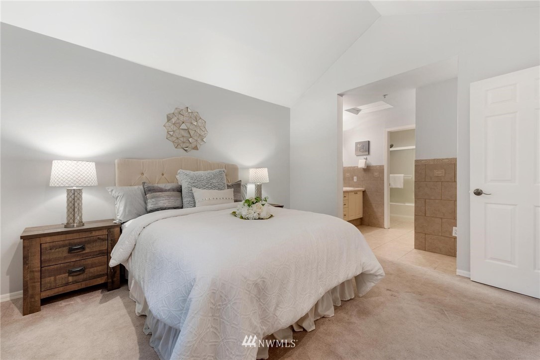 18505 Southeast Newport Way, Unit E320 Issaquah, WA 98027 - Photo 14 of 18 a bedroom with a bed and a night stand