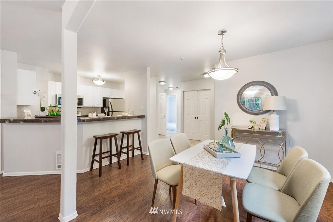 18505 Southeast Newport Way, Unit E320 Issaquah, WA 98027 - Photo 4 of 18 a view of a dining room with furniture and wooden floor