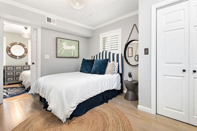 a bedroom with a bed a mirror and a window