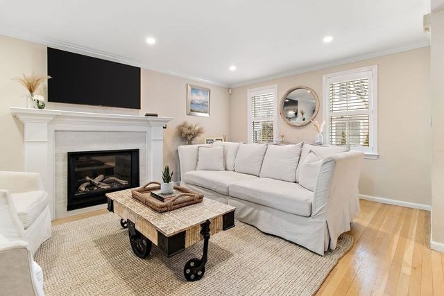 a living room with furniture a fireplace and flat screen tv