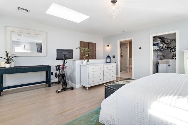 a bedroom with a bed a dresser and mirror