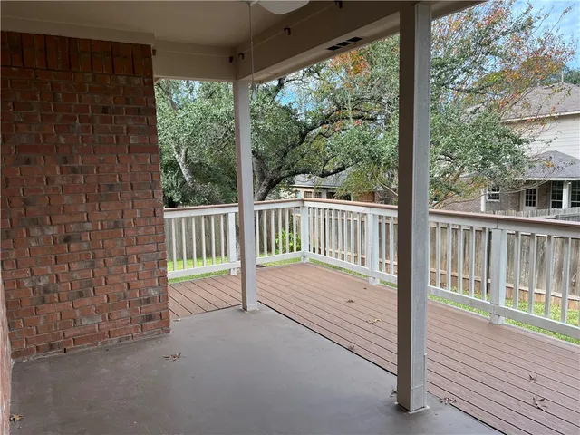 a view of a deck with a large window and wooden fence