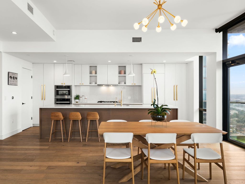 70 Rainey Street, Unit 2301 Austin, TX 78701 - Photo 13 of 40 a kitchen with stainless steel appliances granite countertop a dining table chairs and window