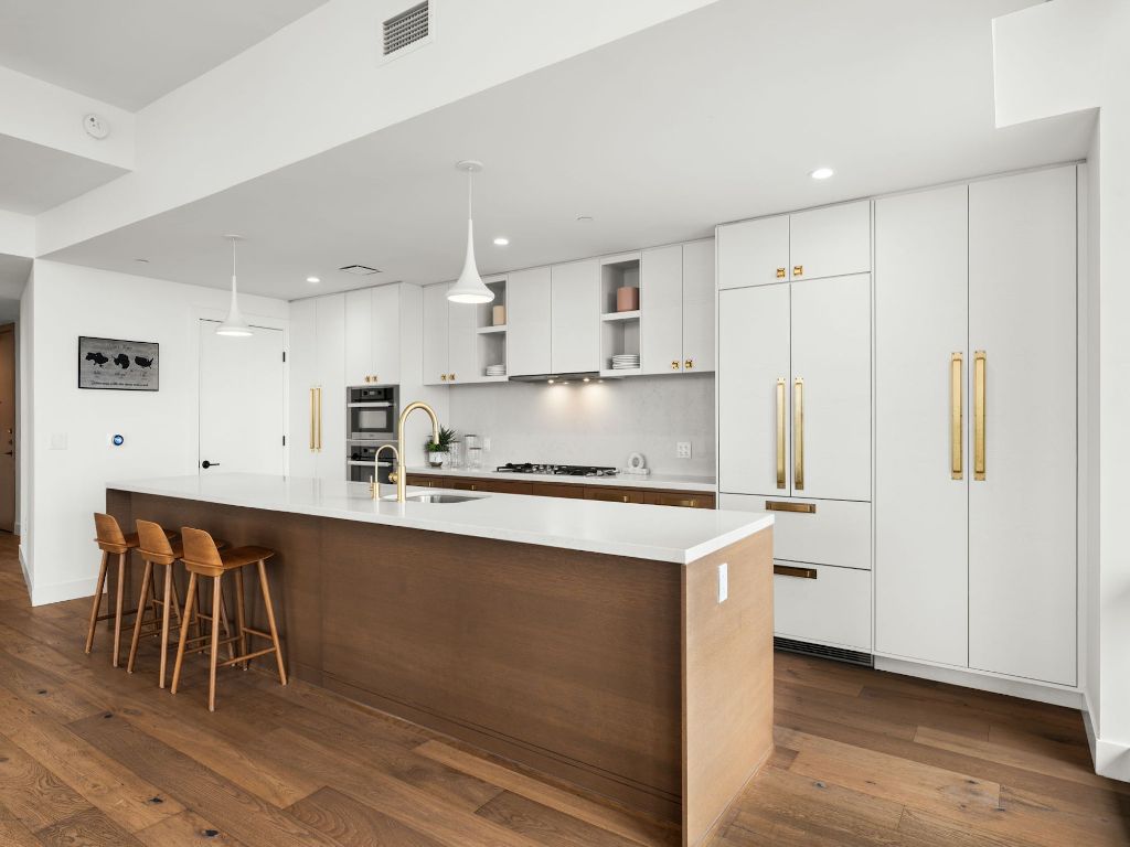 70 Rainey Street, Unit 2301 Austin, TX 78701 - Photo 9 of 40 a kitchen with stainless steel appliances granite countertop a sink a stove a refrigerator and island with wooden floor