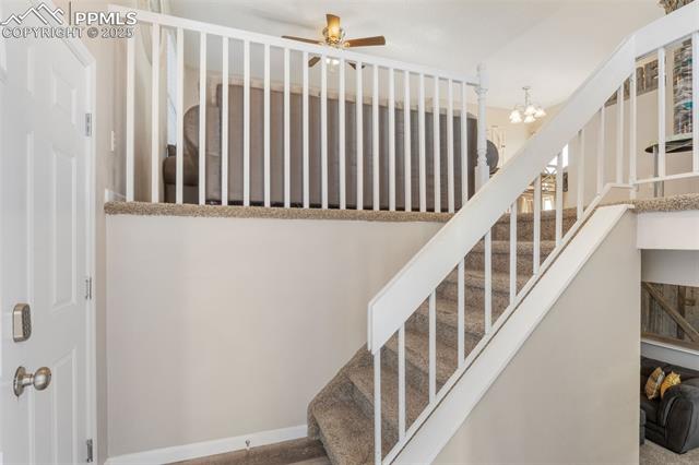 4469 Fenton Road Colorado Springs, CO 80916 - Photo 5 of 38 Stairway with a chandelier and a ceiling fan