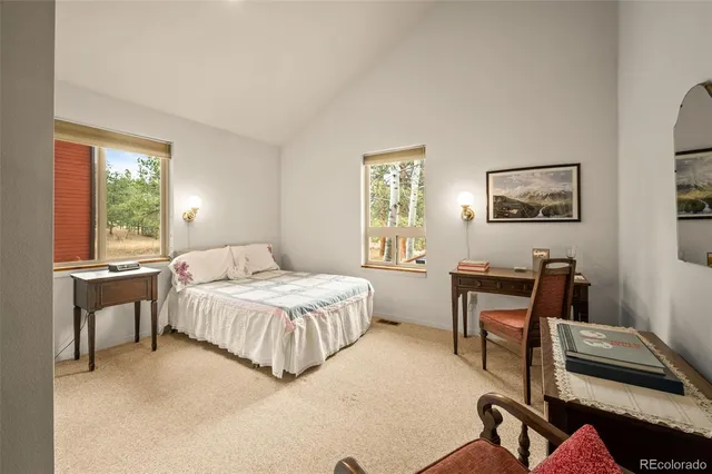 a bedroom with a bed table chair and a window