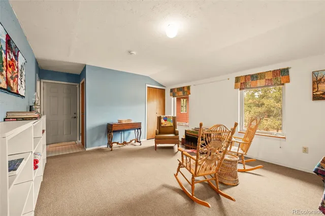 a living room with furniture and a dining table with chair