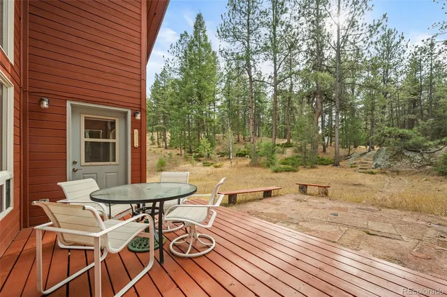 a view of a patio with table and chairs with wooden floor and fence