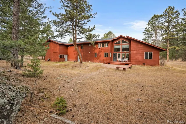 a big house with a small yard and large trees