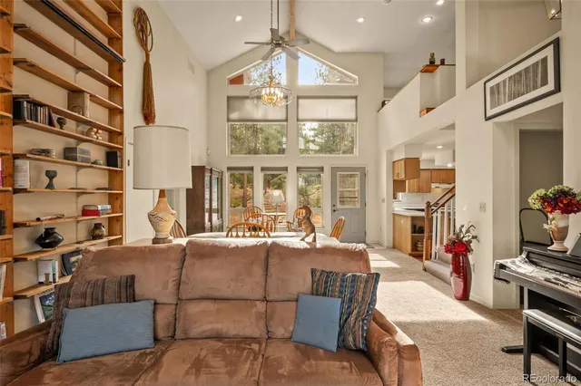 a living room with furniture a flat screen tv and a floor to ceiling window