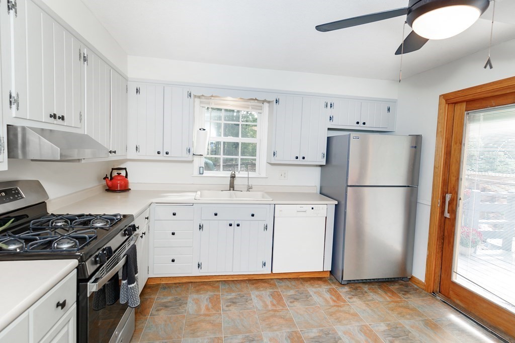 301 Main Road Montgomery, MA 01085 - Photo 15 of 41 a kitchen with granite countertop a refrigerator a sink a stove and white cabinets