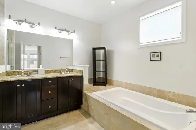 a spacious bathroom with a tub sink and mirror