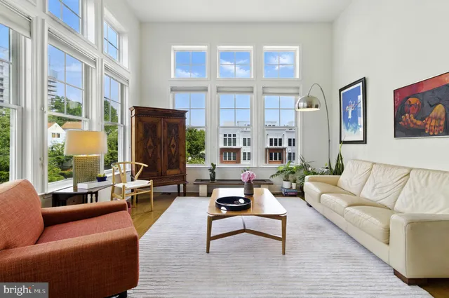 a living room with furniture large windows and a fireplace