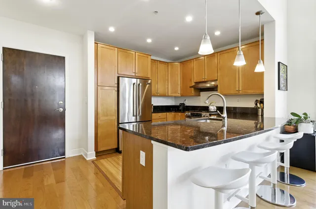 a kitchen with stainless steel appliances granite countertop a sink refrigerator and cabinets