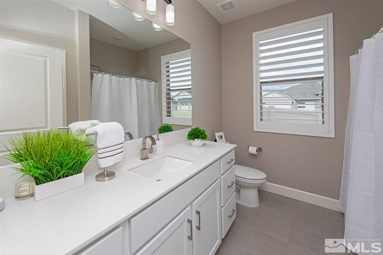 601 Riverbed Circle Reno, NV 89521 - Photo 19 of 31 a bathroom with a granite countertop sink a mirror and a toilet