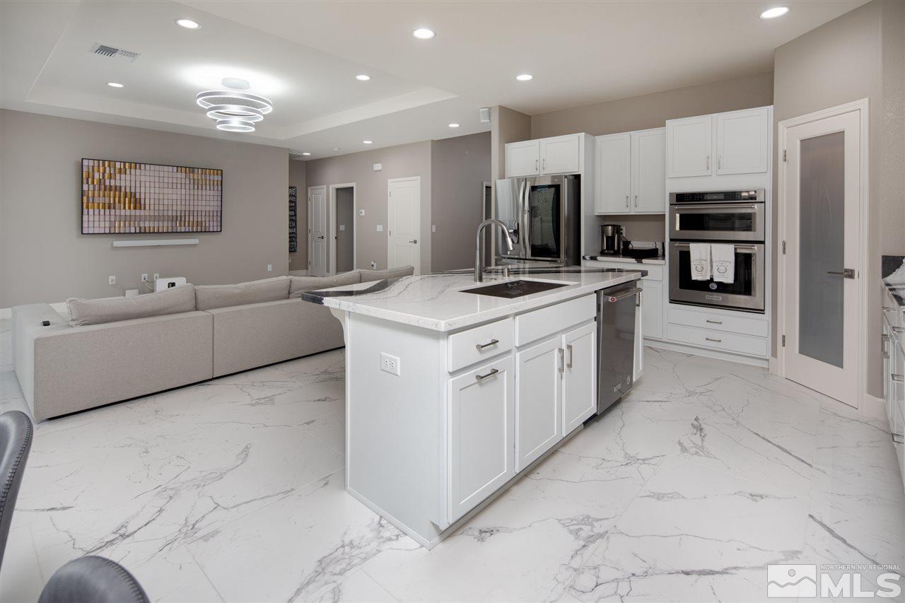 601 Riverbed Circle Reno, NV 89521 - Photo 26 of 31 a kitchen with stainless steel appliances kitchen island granite countertop a sink and cabinets