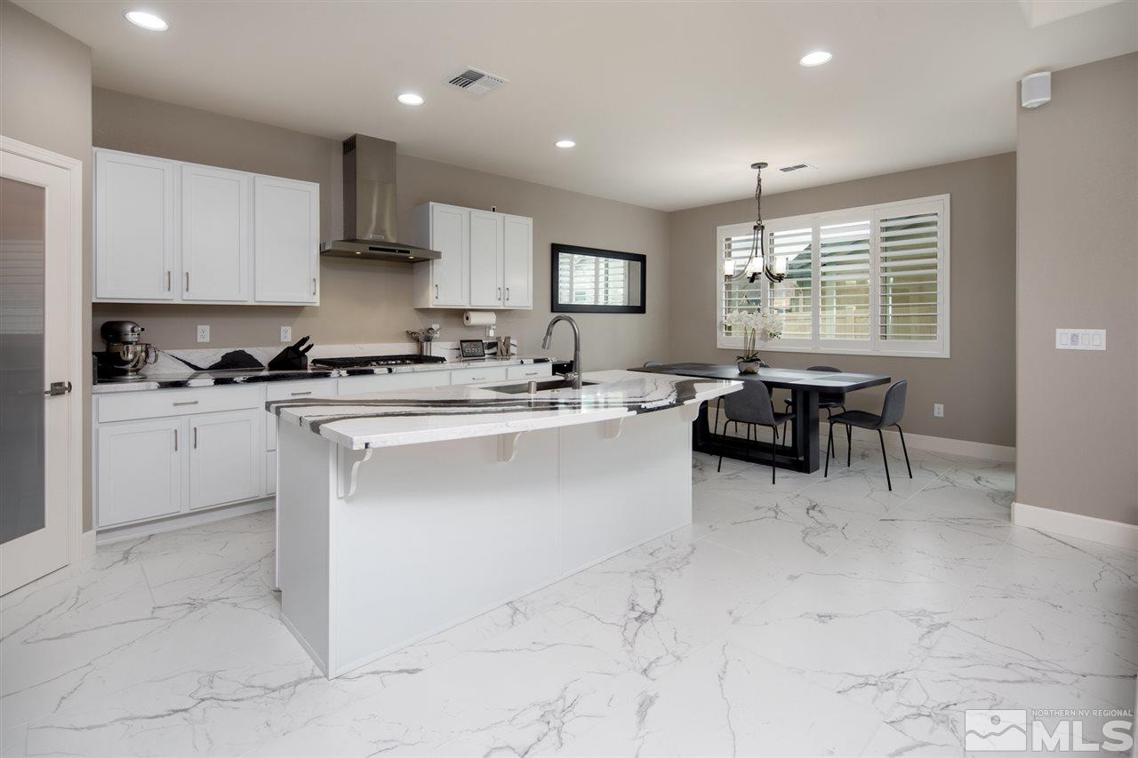 601 Riverbed Circle Reno, NV 89521 - Photo 5 of 31 a kitchen with stainless steel appliances a sink a stove a refrigerator cabinets and dining table