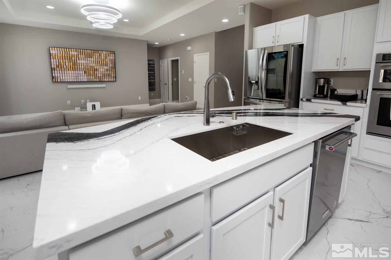601 Riverbed Circle Reno, NV 89521 - Photo 8 of 31 a kitchen with stainless steel appliances granite countertop a sink and a refrigerator
