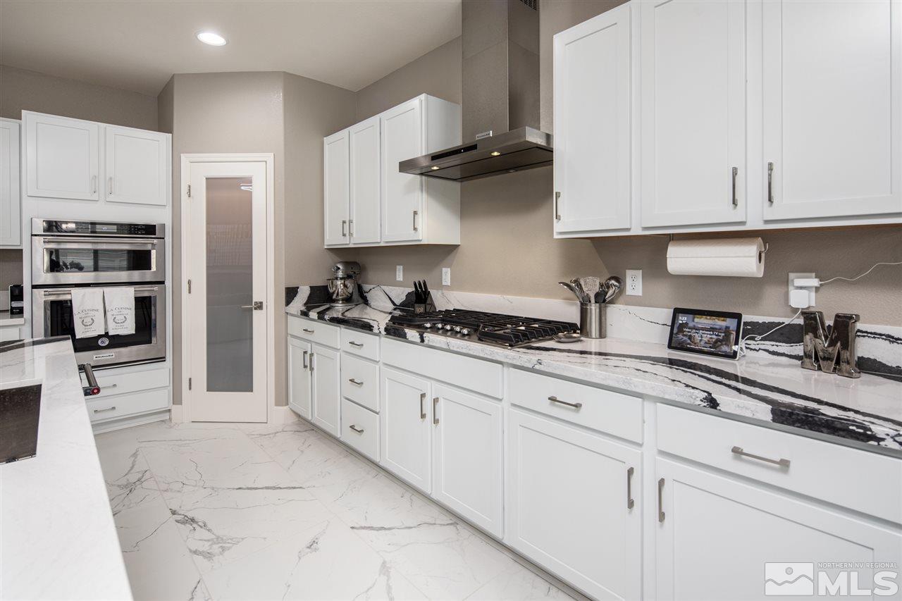 601 Riverbed Circle Reno, NV 89521 - Photo 9 of 31 a kitchen with stainless steel appliances granite countertop white cabinets and a stove