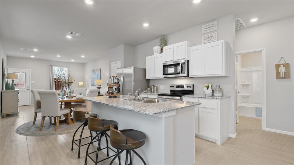 3053 Maple Orch Lane Fort Worth, TX 76140 - Photo 36 of 38 a kitchen with stainless steel appliances kitchen island granite countertop a sink and cabinets