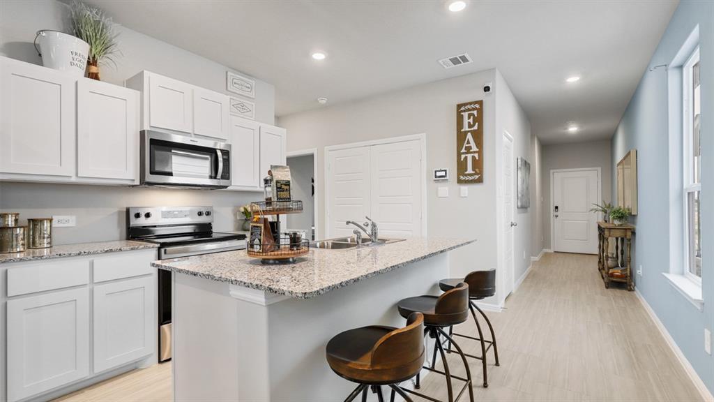 3053 Maple Orch Lane Fort Worth, TX 76140 - Photo 1 of 38 a kitchen with granite countertop stainless steel appliances a stove sink microwave and cabinets